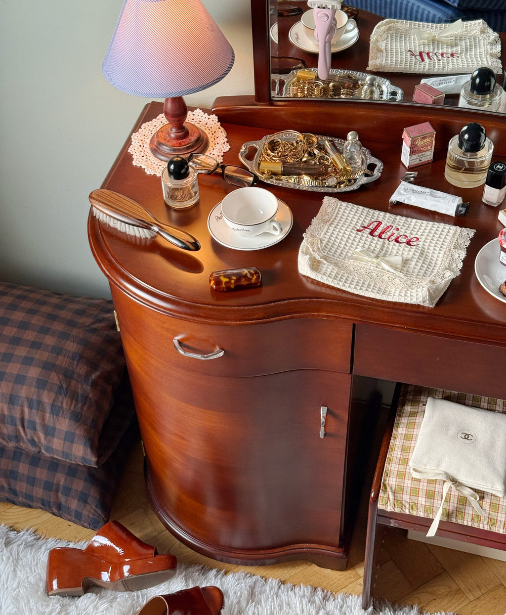 Wooden desk with various items including a lamp, cups, and a tray.