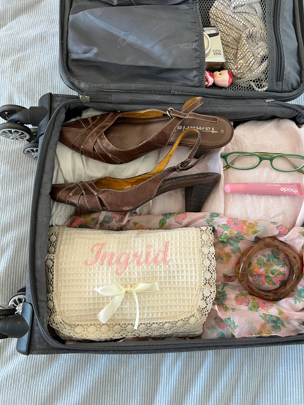 Personalized and Custom embroidered makeup bag in suitcase. Custom quilted by Roos, featuring a romantic design. Perfect for travel and beauty essentials.