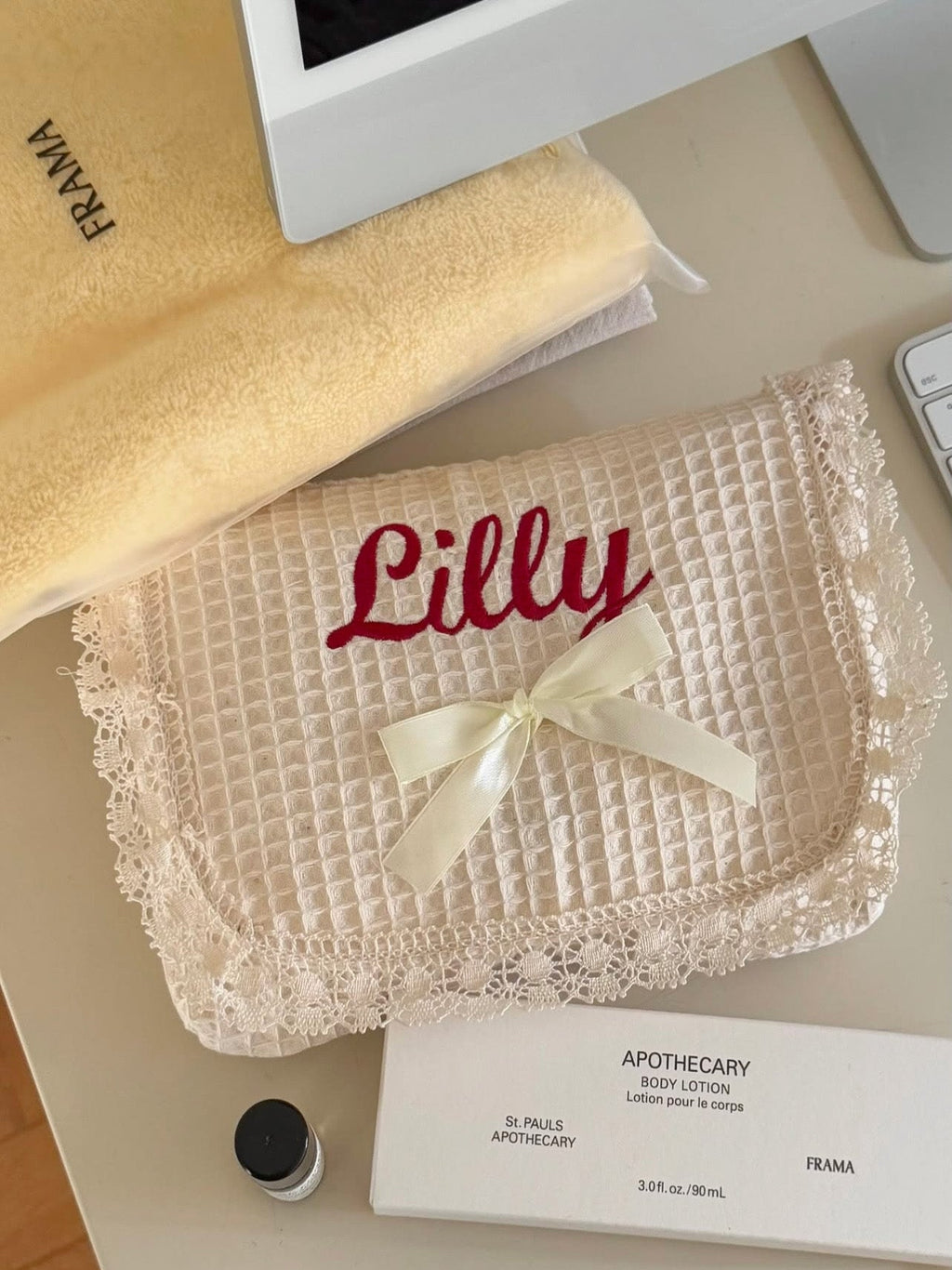 Personalized quilted makeup bag in soft cotton with lace trim and silky bow, embroidered with name in red